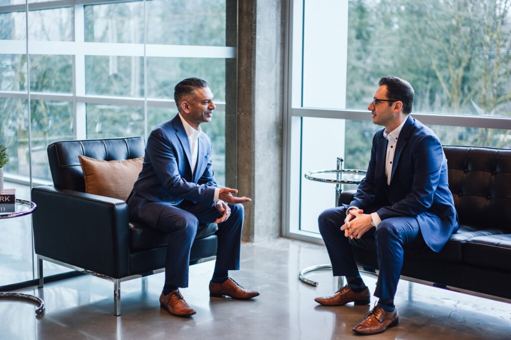 Two businessmen sitting on sofas in an office