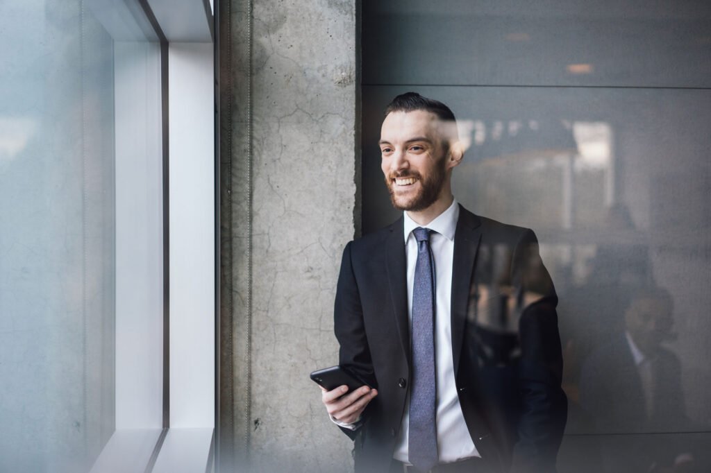 man with cellphone near a window