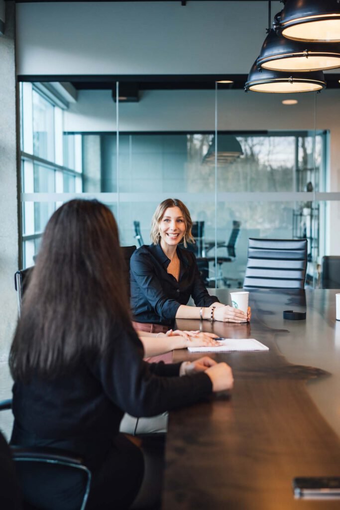 Two people sitting at a meeting desk with laptops